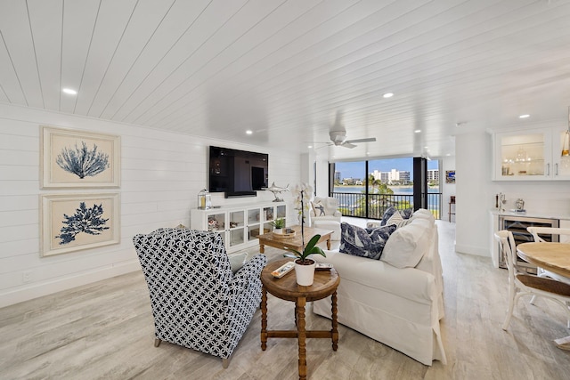 living room with ceiling fan, a wall of windows, wood ceiling, and light hardwood / wood-style floors