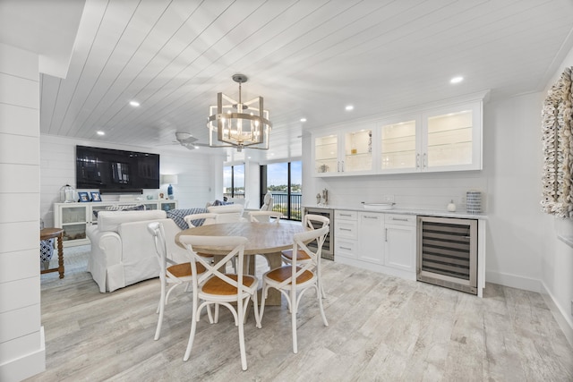 dining space with wine cooler, light hardwood / wood-style flooring, a chandelier, and wood ceiling