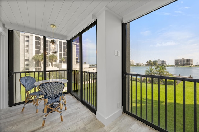 sunroom / solarium with a water view and wooden ceiling