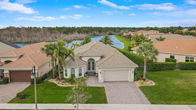 view of front of property with a front yard, a garage, and a water view