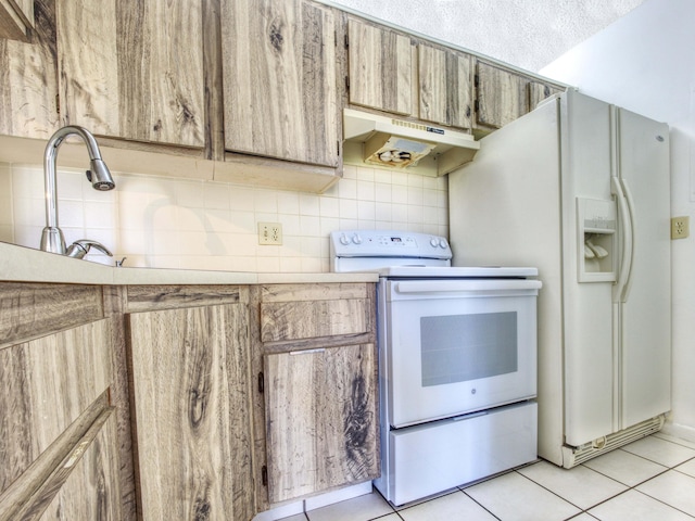 kitchen featuring light tile patterned flooring, a textured ceiling, white appliances, and decorative backsplash