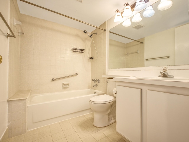 full bathroom with tile patterned floors, tiled shower / bath combo, vanity, and toilet