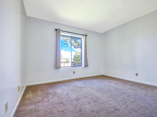 carpeted empty room with a textured ceiling