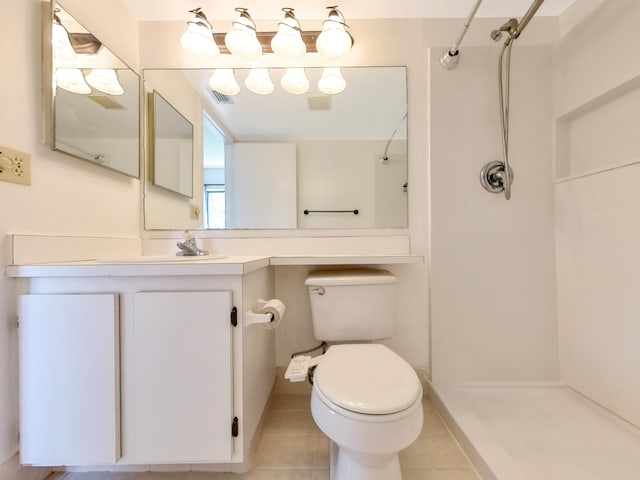 bathroom with vanity, a shower, toilet, and tile patterned floors