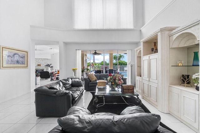 living room featuring a high ceiling, light tile patterned floors, and ceiling fan