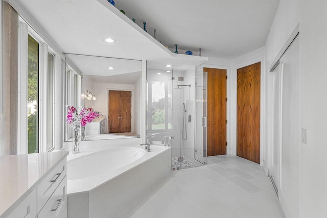 bathroom featuring independent shower and bath, vanity, and tile patterned floors