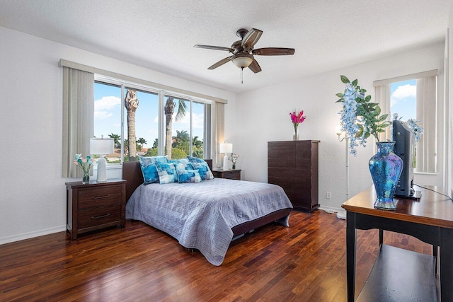 bedroom with ceiling fan, a textured ceiling, and dark hardwood / wood-style flooring