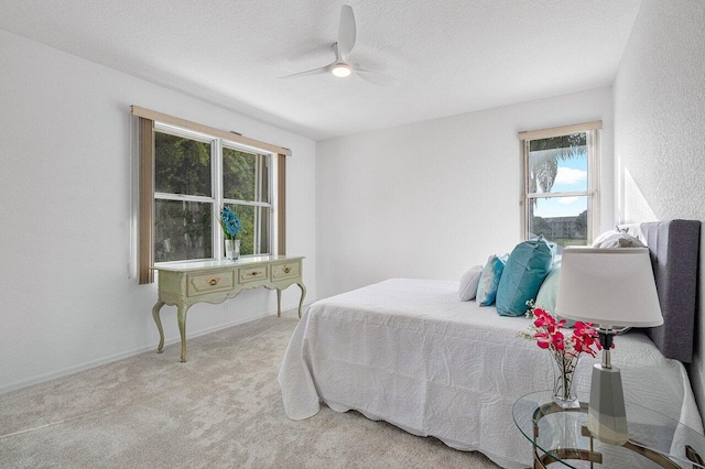 carpeted bedroom featuring multiple windows, ceiling fan, and a textured ceiling