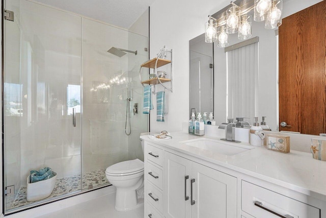 bathroom with vanity, a shower with door, and toilet