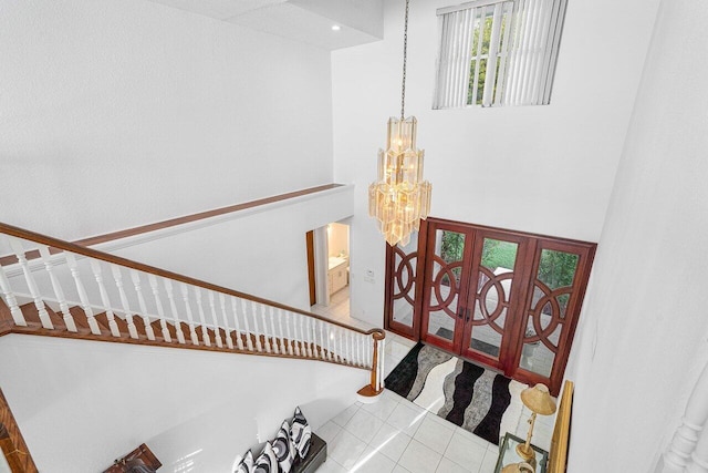 stairway with tile patterned floors and a chandelier