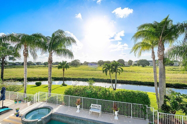 view of swimming pool featuring an in ground hot tub, a water view, and a rural view