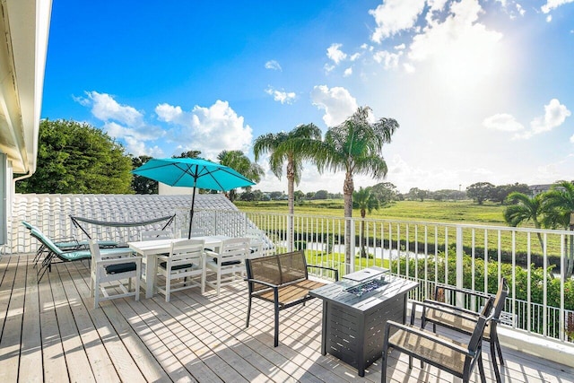 deck with an outdoor fire pit and a water view