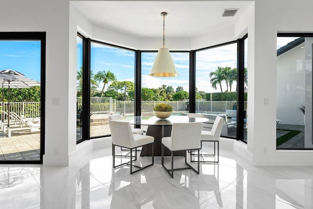 kitchen featuring a large island, light stone counters, and decorative light fixtures