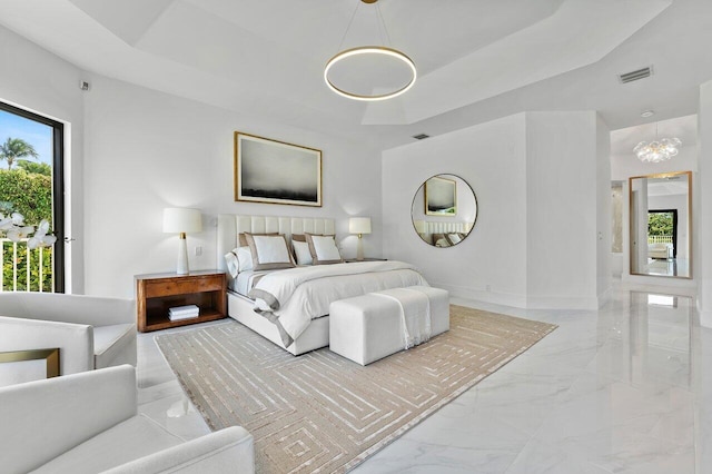 bedroom with a notable chandelier and a tray ceiling