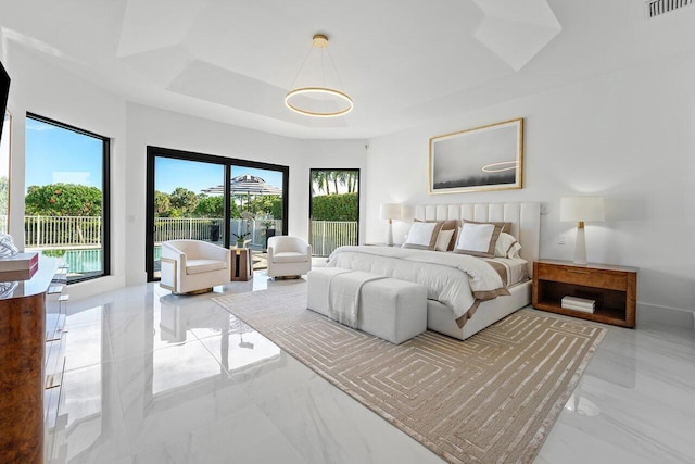 bedroom featuring a tray ceiling and a chandelier