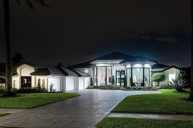 view of front of home with a lawn and a garage