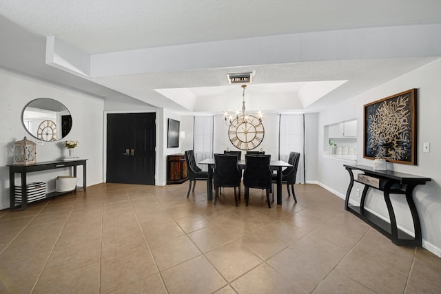 dining area featuring a chandelier, a textured ceiling, a raised ceiling, and light tile patterned floors