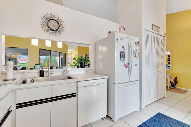 kitchen with white appliances, sink, light tile patterned flooring, and white cabinets