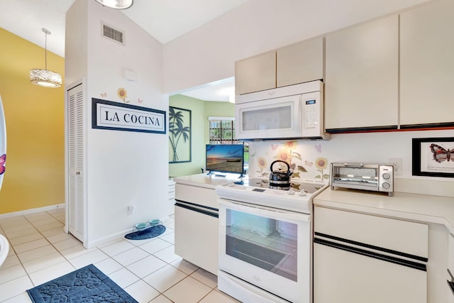 kitchen with pendant lighting, white appliances, vaulted ceiling, and light tile patterned floors