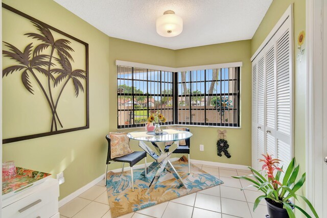 dining area with a textured ceiling and light tile patterned floors