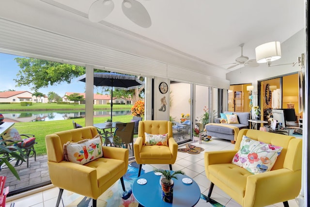 sunroom / solarium with ceiling fan and a water view