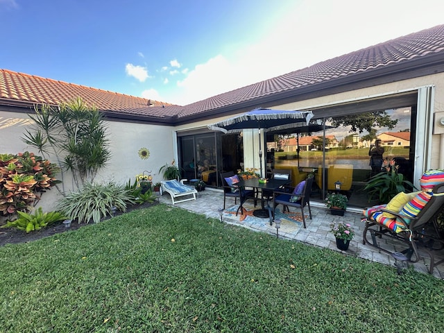 back of house featuring a lawn and a patio area