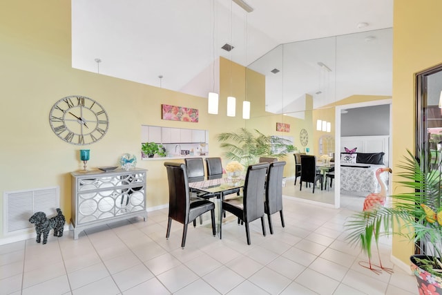 dining room with high vaulted ceiling and light tile patterned floors