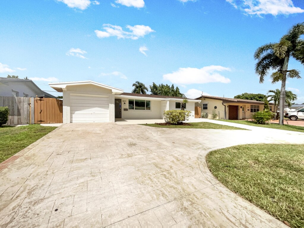 single story home with a garage and a front lawn