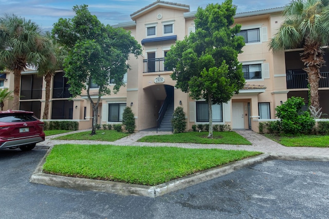 view of front of property with a balcony and a front yard