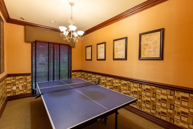 game room with dark carpet, ornamental molding, and a chandelier