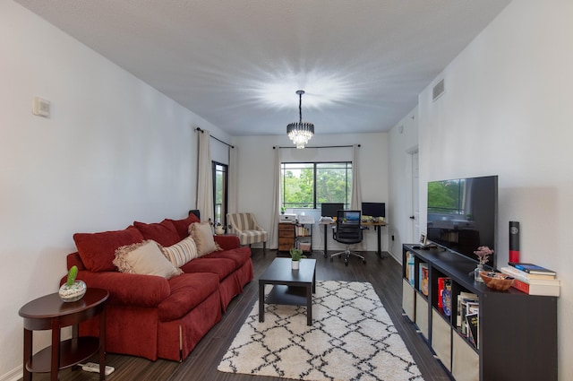 living room with dark hardwood / wood-style flooring and a chandelier