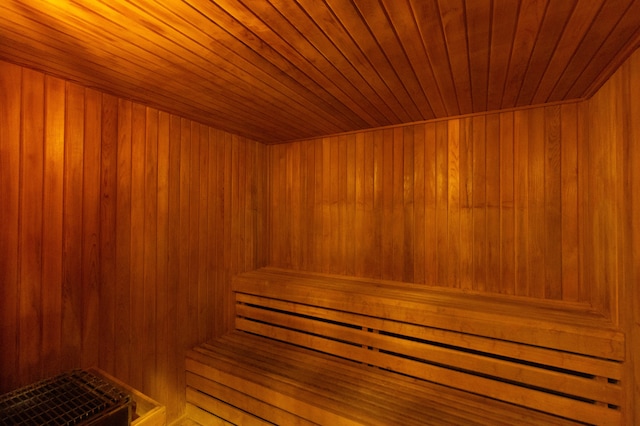 view of sauna featuring wood ceiling and wood walls