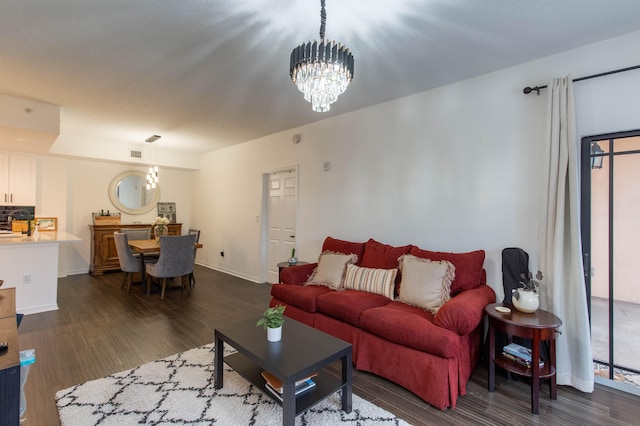 living room featuring a chandelier and dark wood-type flooring