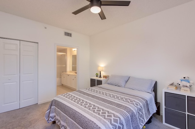 bedroom with ceiling fan, light colored carpet, and a closet