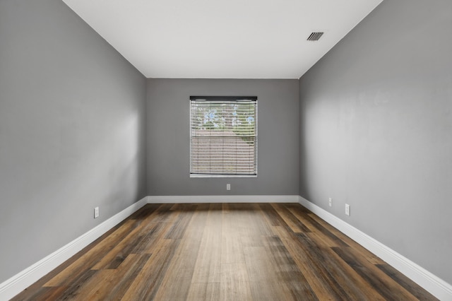 empty room with dark hardwood / wood-style flooring