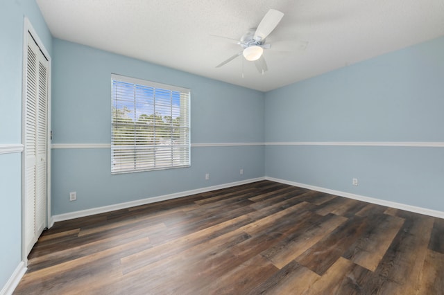 unfurnished bedroom with dark hardwood / wood-style floors, a closet, and ceiling fan