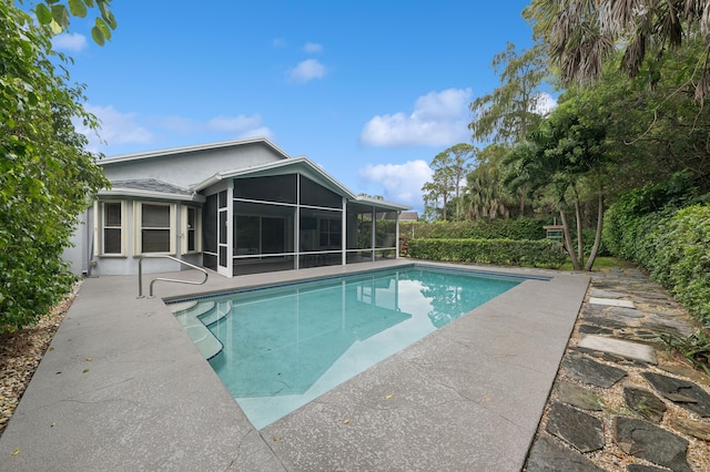 view of swimming pool with a sunroom and a patio area