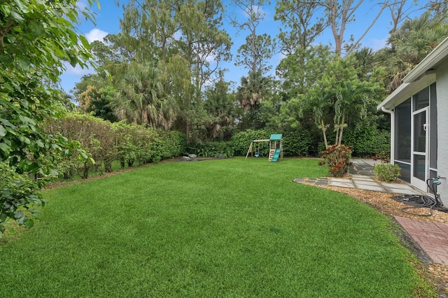 view of yard with a playground and a sunroom