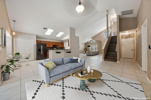 living room featuring light tile patterned floors and lofted ceiling with skylight