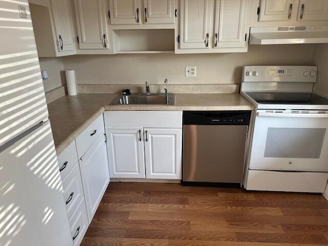 kitchen featuring white cabinetry, electric stove, range hood, stainless steel dishwasher, and sink