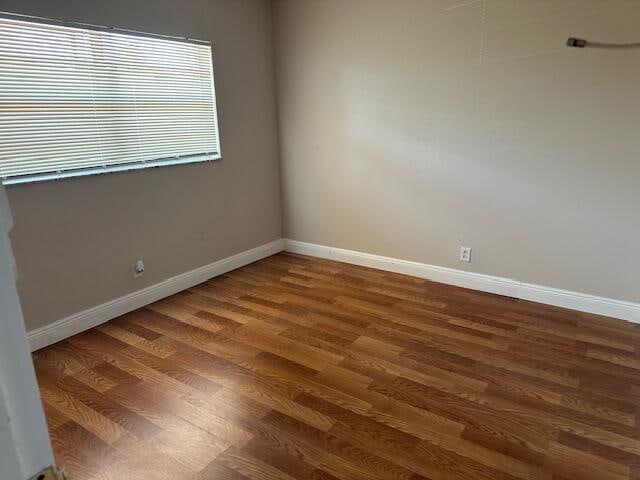 spare room with dark hardwood / wood-style flooring