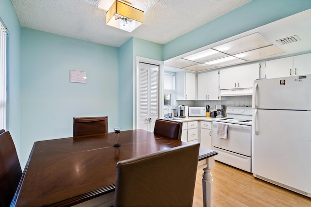 kitchen with white appliances, a textured ceiling, backsplash, white cabinetry, and light wood-type flooring