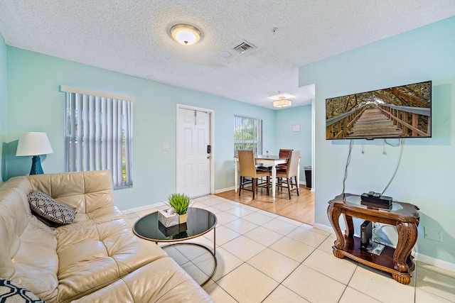 living room with a textured ceiling and light tile patterned floors