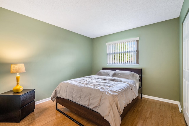 bedroom with wood-type flooring and a textured ceiling