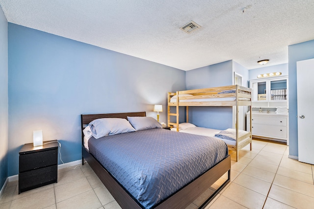 tiled bedroom featuring a textured ceiling