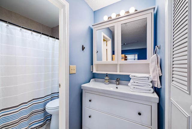 bathroom featuring a textured ceiling, vanity, and toilet