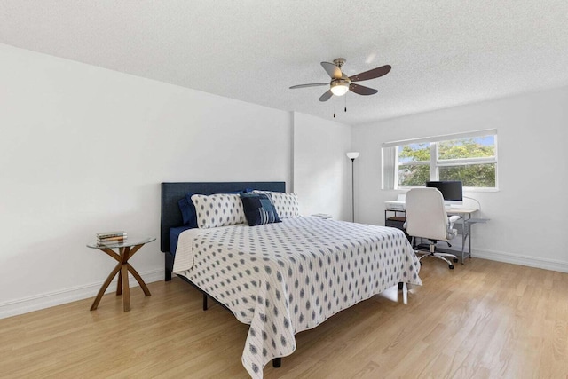 bedroom with light wood-type flooring, a textured ceiling, and ceiling fan