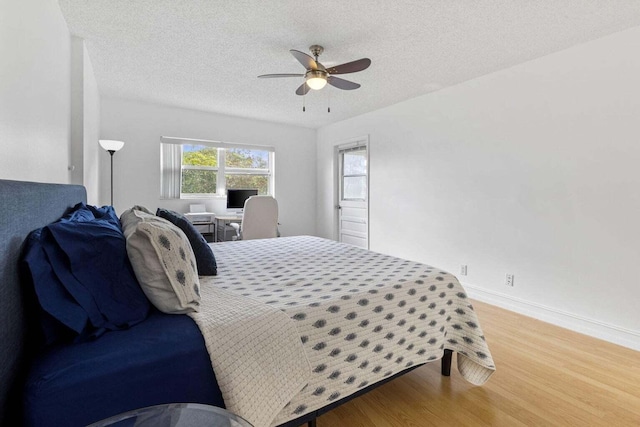 bedroom featuring a textured ceiling, wood-type flooring, and ceiling fan