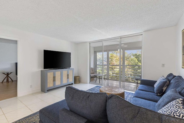 tiled living room featuring floor to ceiling windows and a textured ceiling