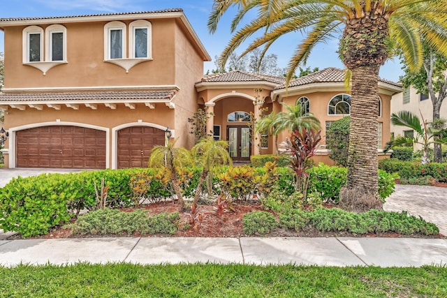 mediterranean / spanish home with french doors and a garage